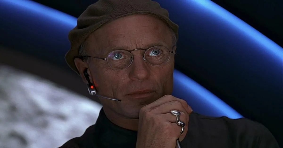 The Truman Show reaction image showing the director in a headset, resting a hand near his chin.