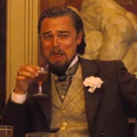Laughing Leo meme showing Calvin Candie in a gold waistcoat with a glass and amused expression.