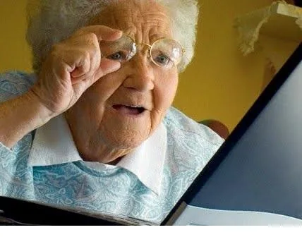 Old Lady at Computer meme showing a woman lifting her glasses beside a screen.